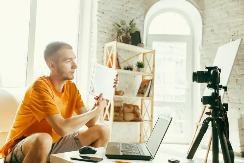 Estrategias de marketing exitosas aplicadas por un hombre creando contenido frente a una cámara y una computadora